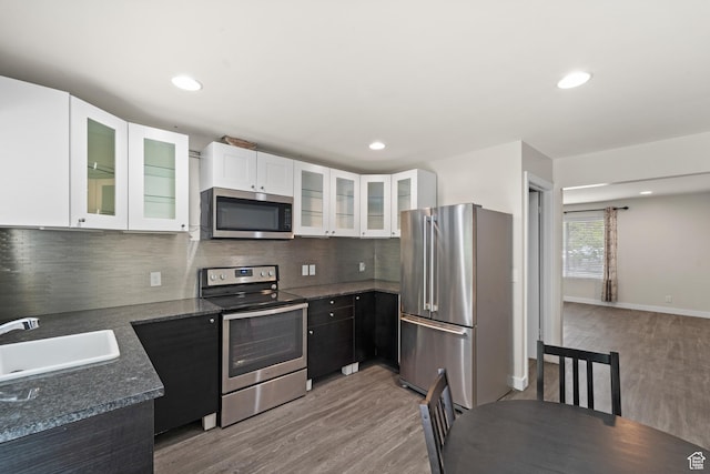 kitchen with stainless steel appliances, a sink, light wood-type flooring, white cabinets, and recessed lighting
