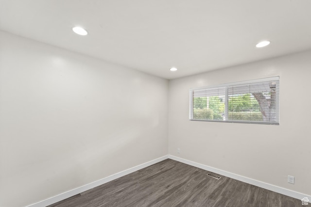 spare room featuring dark wood-style floors, baseboards, and recessed lighting