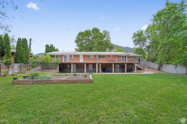 rear view of house with stairway, a deck with mountain view, and a patio area