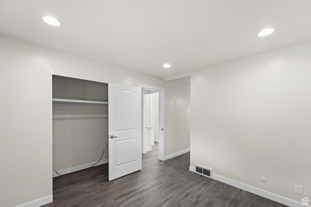 unfurnished bedroom featuring baseboards, dark wood-style floors, a closet, and recessed lighting