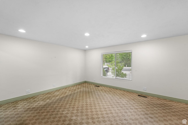 carpeted empty room featuring recessed lighting and baseboards