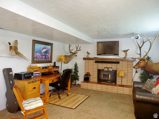 carpeted office space with a wood stove and a textured ceiling