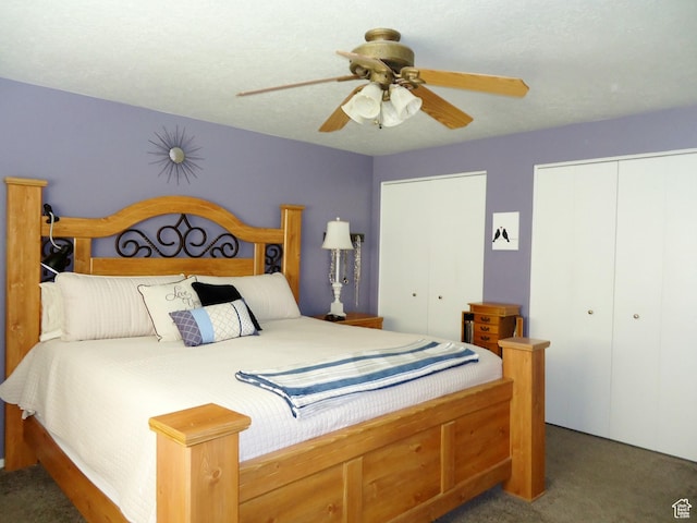 carpeted bedroom with multiple closets and a ceiling fan
