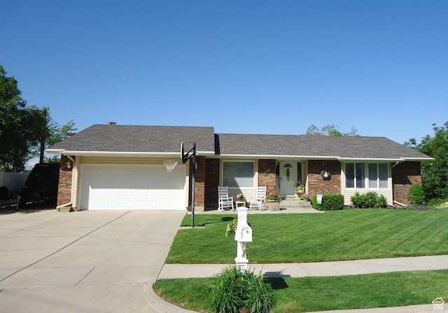 single story home featuring brick siding, an attached garage, concrete driveway, and a front yard