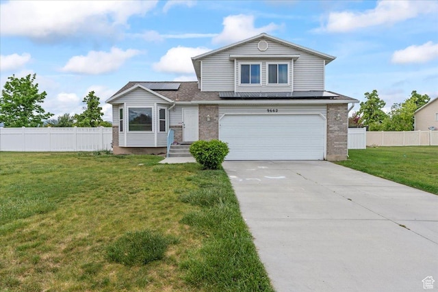 view of front of house with a garage, roof mounted solar panels, concrete driveway, and brick siding