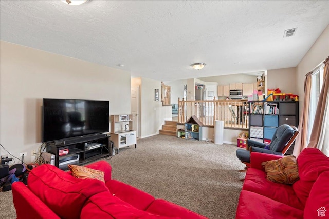 living area featuring carpet floors, a textured ceiling, stairway, and baseboards