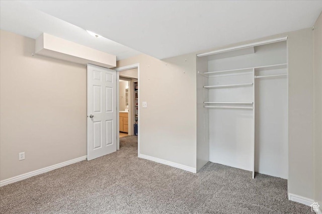unfurnished bedroom featuring carpet, a closet, and baseboards