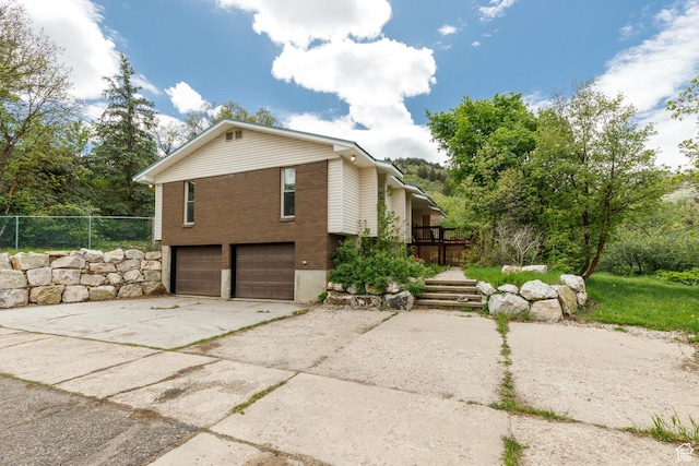 2147 N 3850 E, Eden, UT 84310 - view of side of property with brick siding, an attached garage, driveway, and fence