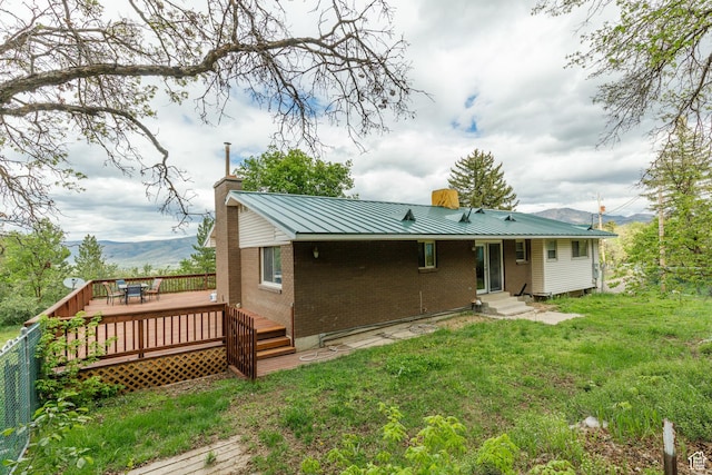 2147 N 3850 E, Eden, UT 84310 - back of house with brick siding, a chimney, a wooden deck, metal roof, and a yard