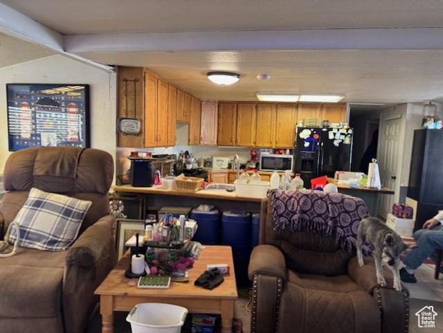 398 N 1st E, Manila, UT 84046 - kitchen featuring stainless steel microwave, open floor plan, black fridge, a peninsula, and light countertops