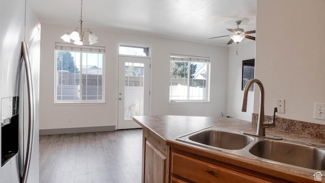 635 E 60 S Unit A-3, American Fork, UT 84003 - kitchen with stainless steel fridge, a sink, brown cabinetry, a chandelier, and light wood-type flooring