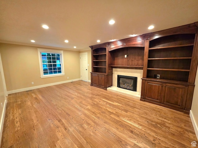 242 W 1100 S, Orem, UT 84058 - unfurnished living room with baseboards, crown molding, recessed lighting, a fireplace with raised hearth, and light wood-style floors