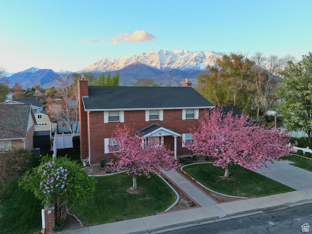 242 W 1100 S, Orem, UT 84058 - colonial inspired home with a chimney, a mountain view, a front lawn, and brick siding