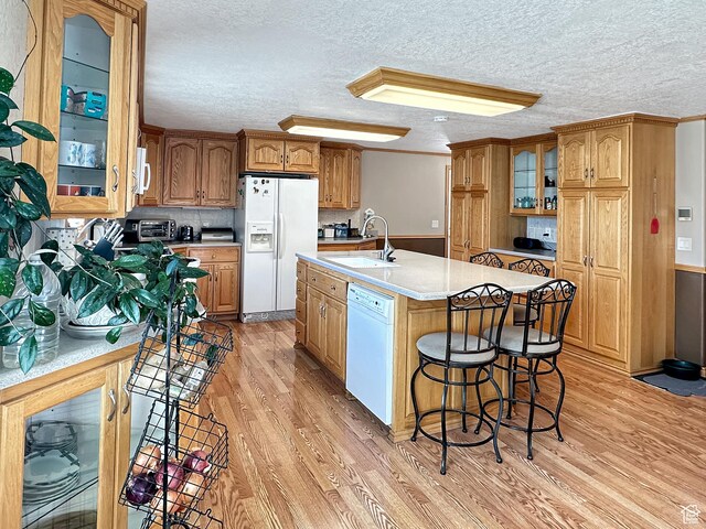 415 N Cedar Vw, Orangeville, UT 84537 - kitchen featuring white appliances, a sink, light wood finished floors, light countertops, and glass insert cabinets