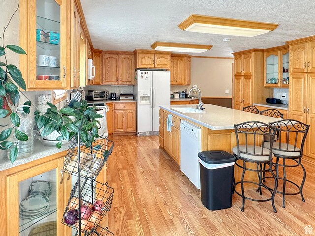 415 N Cedar Vw, Orangeville, UT 84537 - kitchen with white appliances, a sink, light countertops, light wood-type flooring, and a kitchen island with sink