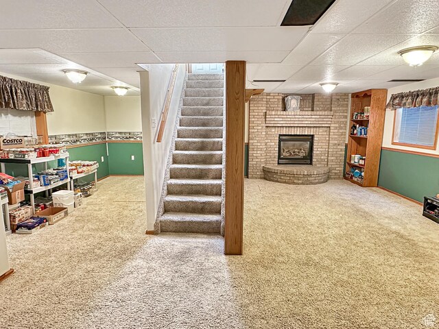 415 N Cedar Vw, Orangeville, UT 84537 - basement with a paneled ceiling, a brick fireplace, stairs, carpet flooring, and baseboards