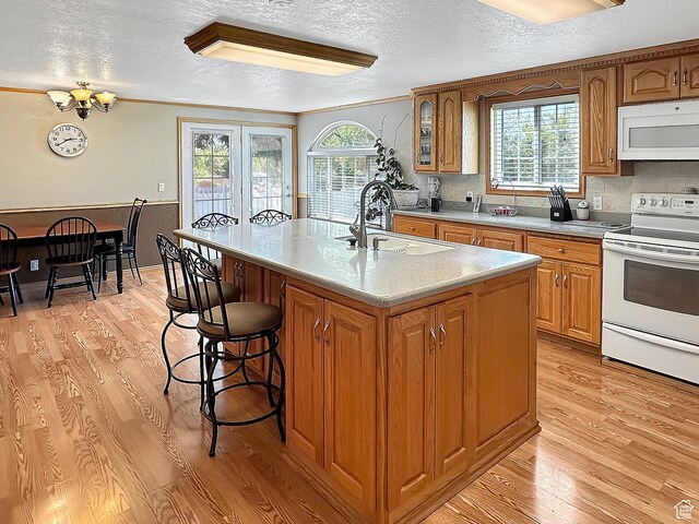415 N Cedar Vw, Orangeville, UT 84537 - kitchen featuring white appliances, a sink, a textured ceiling, light wood finished floors, and brown cabinetry