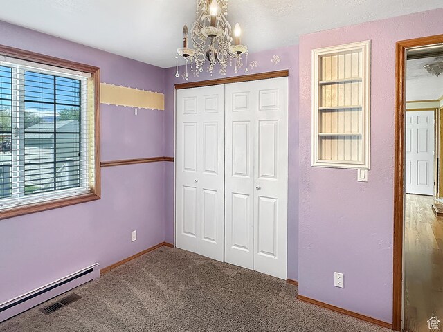 415 N Cedar Vw, Orangeville, UT 84537 - unfurnished bedroom featuring a chandelier, a closet, baseboard heating, baseboards, and a textured wall