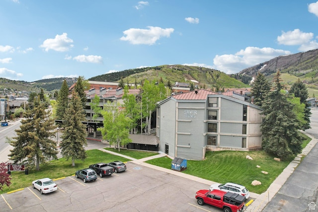 view of building exterior featuring uncovered parking and a mountain view