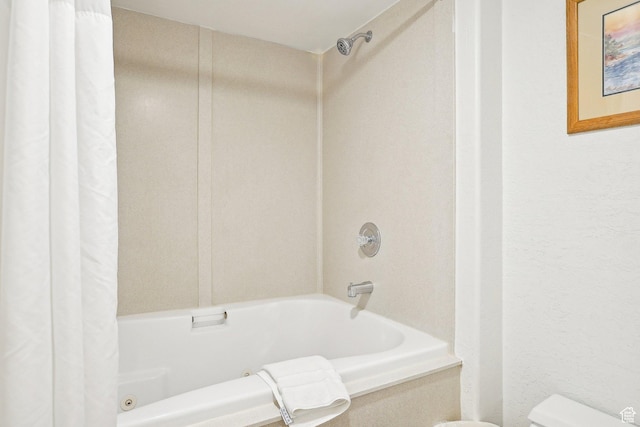 bathroom with shower / bath combination with curtain and toilet