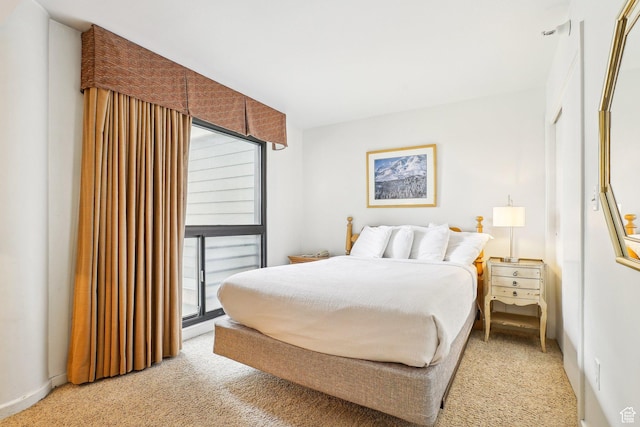 bedroom with light carpet, multiple windows, and access to outside