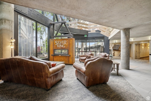 living area featuring decorative columns and lofted ceiling