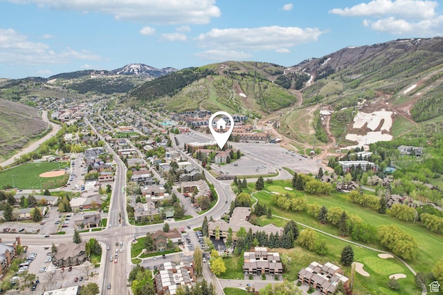 aerial view of property's location featuring a mountainous background and nearby suburban area