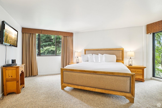 bedroom featuring light colored carpet and baseboards