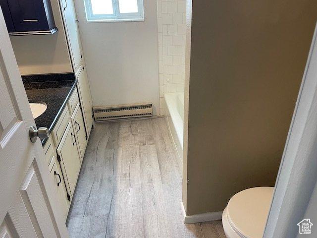 285 W 600 N Unit 3, Logan, UT 84321 - full bathroom with a baseboard radiator, wood finished floors, toilet, and vanity