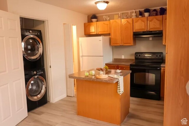 285 W 600 N Unit 3, Logan, UT 84321 - kitchen with electric range, under cabinet range hood, stacked washing machine and dryer, freestanding refrigerator, and light wood finished floors