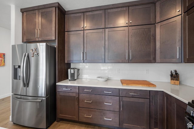 703 W Swinley Dr, Murray, UT 84123 - kitchen with stainless steel fridge, light wood finished floors, tasteful backsplash, and dark brown cabinets