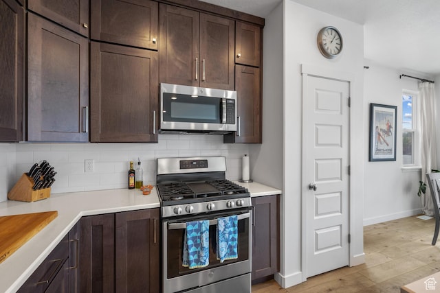 703 W Swinley Dr, Murray, UT 84123 - kitchen featuring stainless steel appliances, dark brown cabinets, tasteful backsplash, and light wood-style flooring
