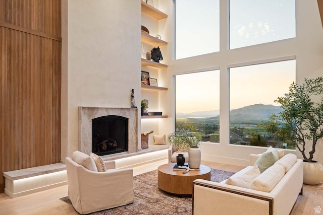 1171 E 430 S, Santaquin, UT 84655 - living room featuring a mountain view, a premium fireplace, light wood-style flooring, a high ceiling, and built in shelves