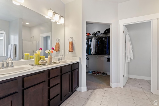14949 S Billings Dr W Unit 119, Herriman, UT 84096 - bathroom featuring tile patterned floors, a walk in closet, double vanity, a shower, and baseboards