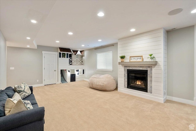 living area with a tiled fireplace, carpet, baseboards, and recessed lighting
