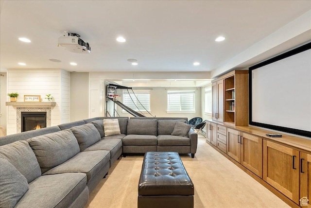 cinema featuring light carpet, recessed lighting, and a glass covered fireplace