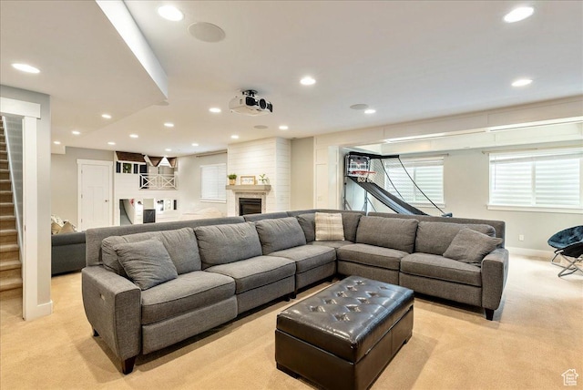 living area with light colored carpet, recessed lighting, stairs, baseboards, and a glass covered fireplace