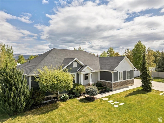 craftsman inspired home featuring stone siding and roof with shingles