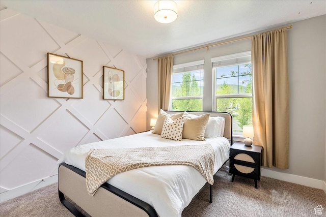 bedroom with light colored carpet and baseboards