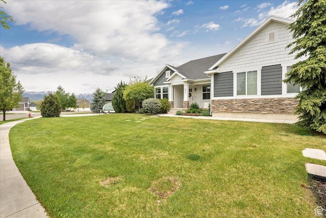 view of front facade with a front yard and stone siding