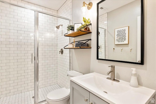 bathroom with a stall shower, toilet, and vanity