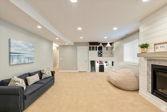 living area featuring recessed lighting, a tiled fireplace, carpet, and baseboards