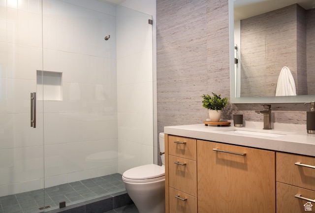 bathroom with toilet, a shower stall, and vanity