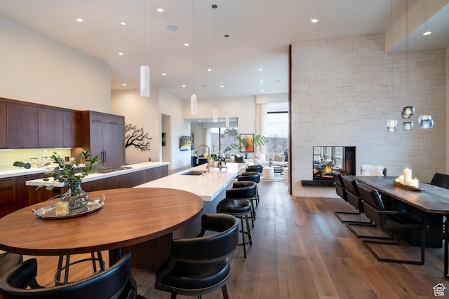 kitchen featuring modern cabinets, a sink, open floor plan, a center island with sink, and light countertops