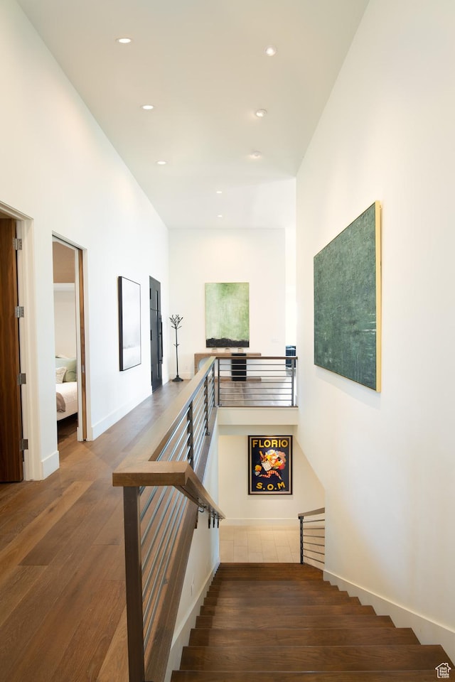 stairs with wood-type flooring, recessed lighting, and baseboards