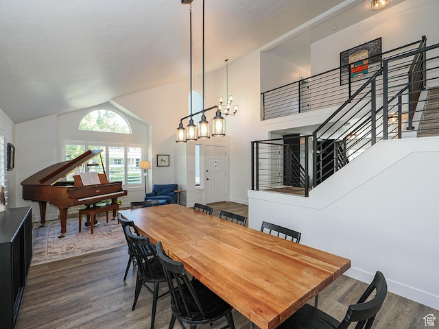 dining room featuring stairway, dark wood-style floors, vaulted ceiling, baseboards, and a chandelier