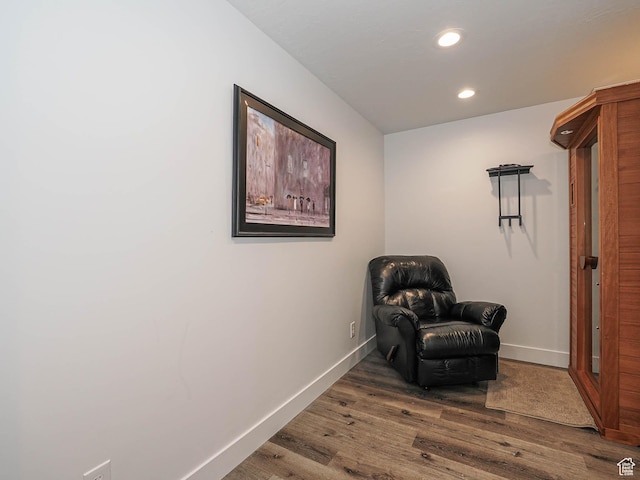 sitting room featuring baseboards, wood finished floors, and recessed lighting