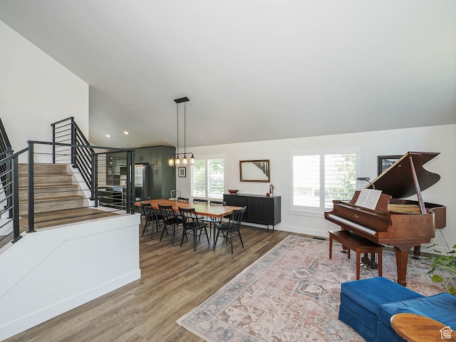 dining space featuring stairway, wood finished floors, baseboards, lofted ceiling, and recessed lighting