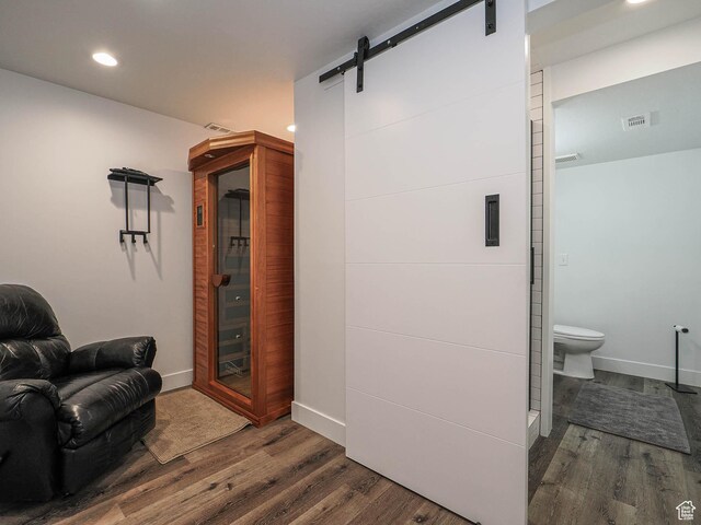 living area featuring dark wood-style flooring, a barn door, recessed lighting, and baseboards