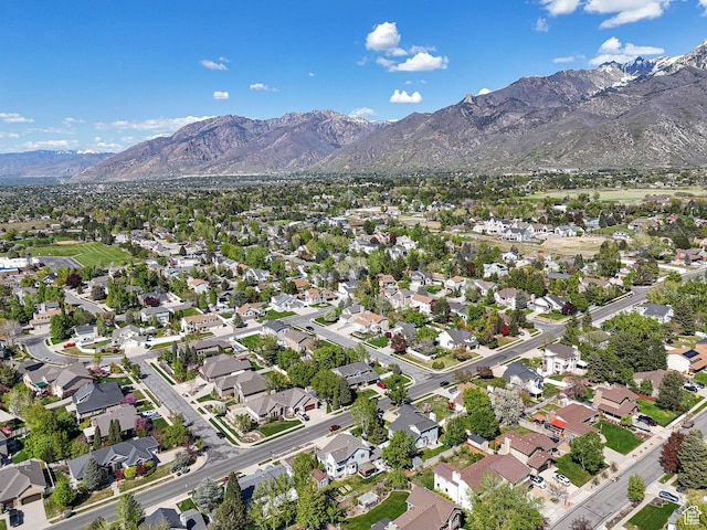 aerial view of property and surrounding area with a mountain backdrop and nearby suburban area